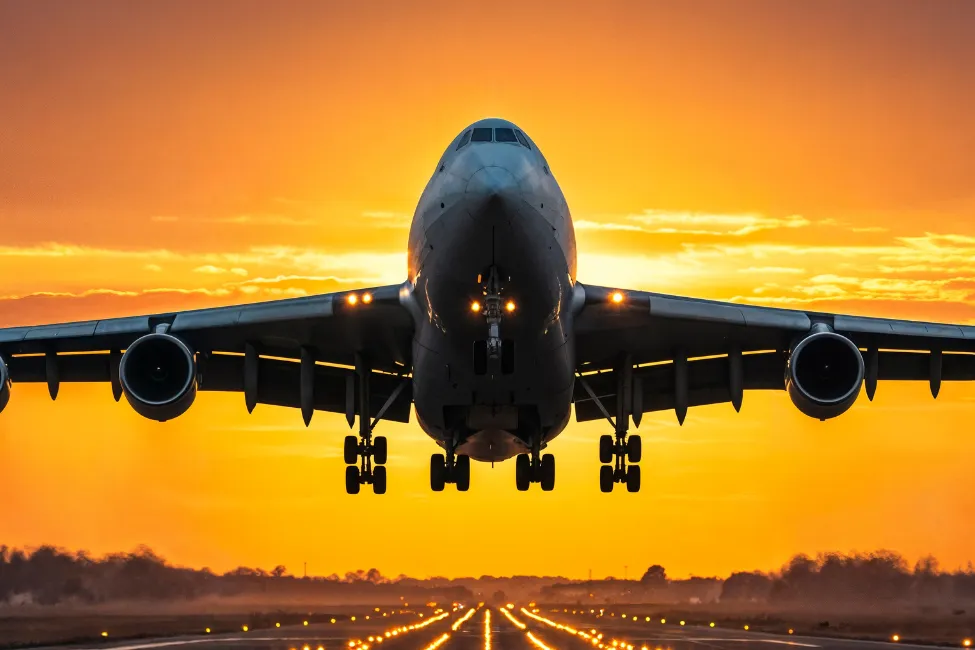 Passenger aircraft taking off at sunset